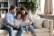 O familie care stă confortabil pe o canapea și se uită împreună la o tabletă